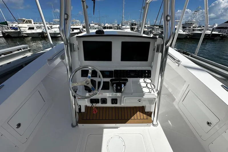  Yacht Photos Pics 2022 Southport 30 FE boat cockpit with steering wheel and dual screens at marina.