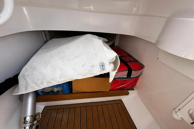  Yacht Photos Pics Storage compartment in a 2022 Southport 30 FE boat with various items.
