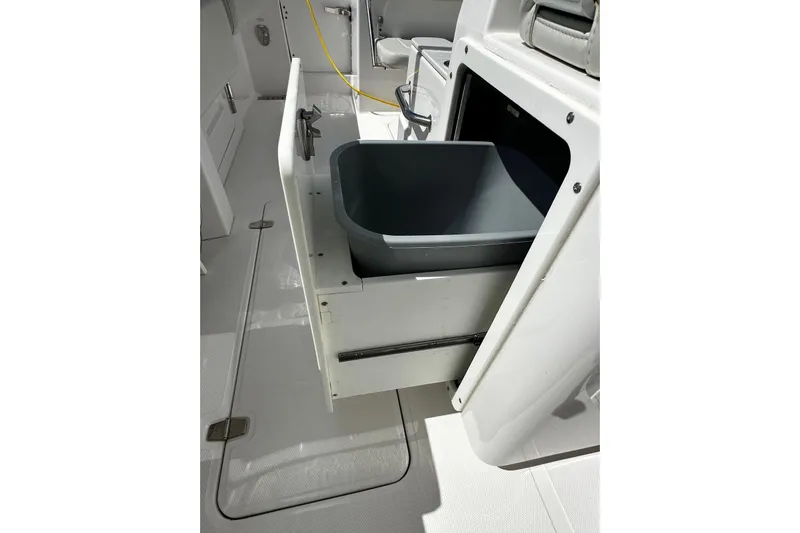  Yacht Photos Pics 2022 Southport 30 FE boat interior with open storage compartment and gray bin.