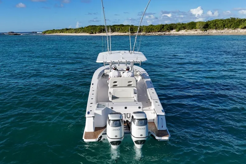  Yacht Photos Pics 2022 Southport 30 FE boat on clear blue water near a lush shoreline.