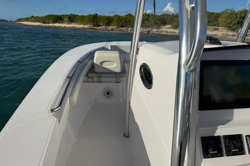  Yacht Photos Pics 2022 Southport 30 FE boat interior with console and seating, near a scenic shoreline.