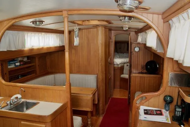 Sara Yacht Photos Pics Interior of 1986 Passport 42 sailboat with wooden furnishings and cozy seating area.