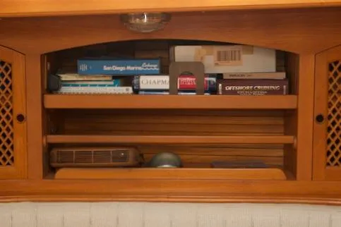 Sara Yacht Photos Pics Wooden shelf with books and items, inside a 1986 Passport 42 model.