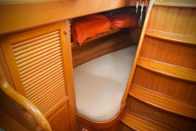 Sara Yacht Photos Pics Cozy wooden cabin interior of 1986 Passport 42 sailboat with bed and storage.
