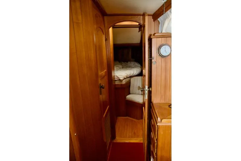 Sara Yacht Photos Pics Cozy wooden interior of 1986 Passport 42 sailboat cabin with bed and clock.