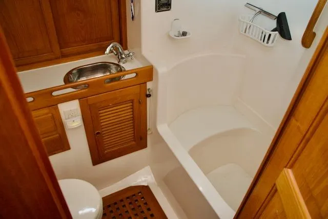 Sara Yacht Photos Pics Compact bathroom in 1986 Passport 42 yacht with wooden cabinetry and stainless steel sink.
