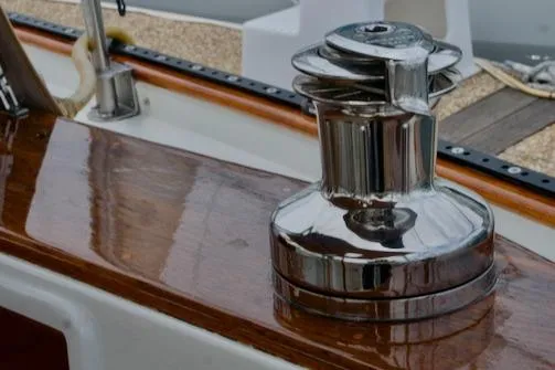 Sara Yacht Photos Pics Shiny winch on 1986 Passport 42 sailboat deck with polished wood finish.