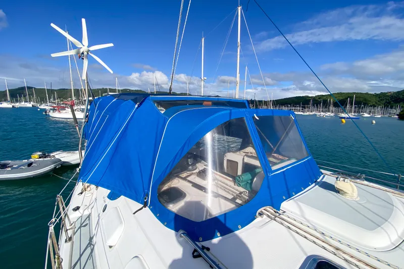  Yacht Photos Pics Sailboat Hunter 41 DS (2006) with blue canopy docked in a marina under clear skies.
