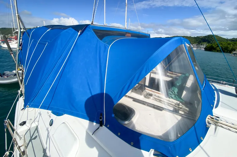  Yacht Photos Pics 2006 Hunter 41 DS sailboat with blue canopy, docked in a scenic marina.