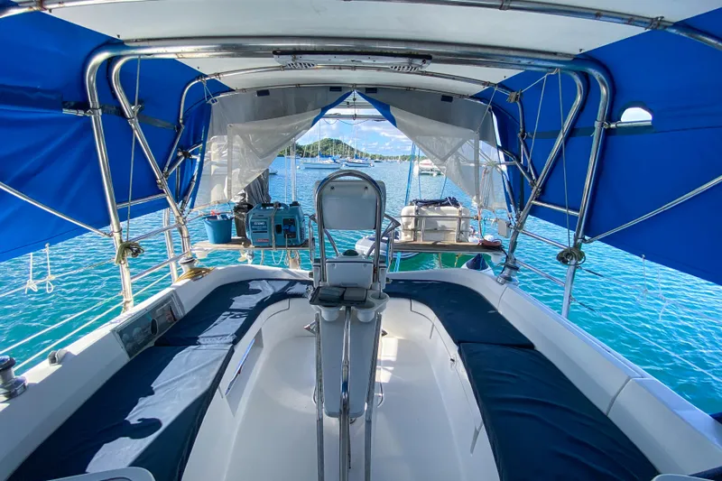  Yacht Photos Pics Cockpit view of 2006 Hunter 41 DS sailboat with blue canopy on clear water.