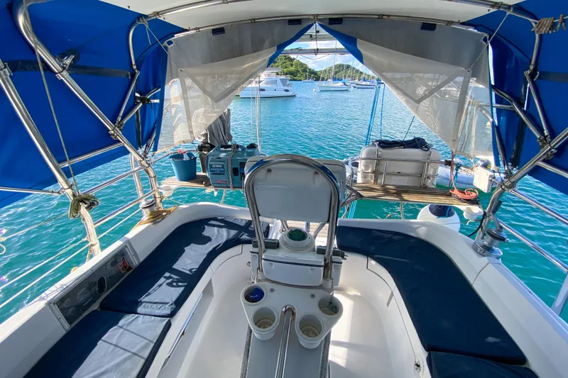  Yacht Photos Pics Cockpit view of 2006 Hunter 41 DS sailboat with blue canopy and ocean backdrop.
