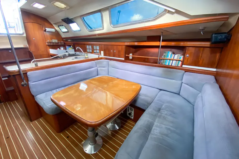  Yacht Photos Pics Interior of 2006 Hunter 41 DS yacht with wooden table and blue seating.