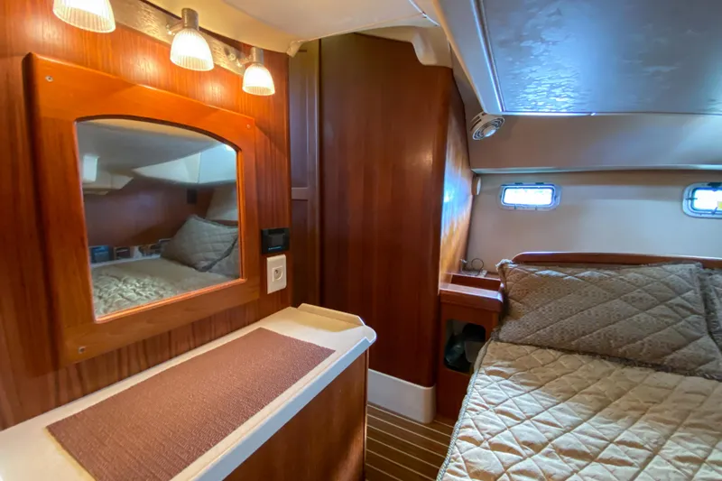  Yacht Photos Pics Interior of 2006 Hunter 41 DS yacht cabin with bed, mirror, and wooden paneling.
