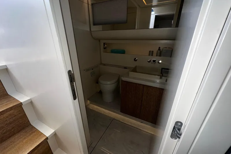 Yanina Yacht Photos Pics Modern yacht bathroom with wooden accents, featuring a toilet and sink. CNM 54, 2019 model.