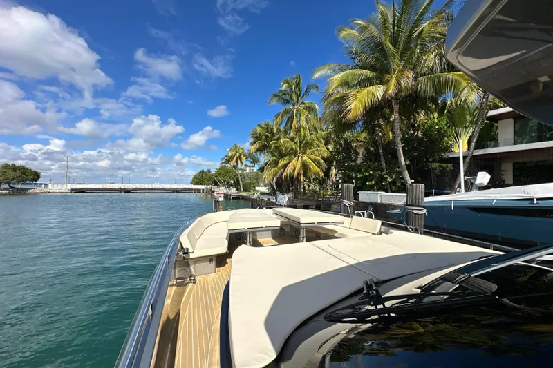 Yanina Yacht Photos Pics Luxurious CNM 54 yacht docked by palm trees, clear blue sky, and calm waters.