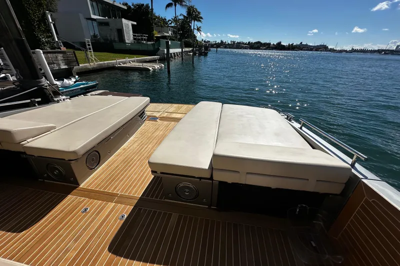 Yanina Yacht Photos Pics Luxurious CNM 54 yacht deck with sun loungers, overlooking serene waterfront, 2019 model.
