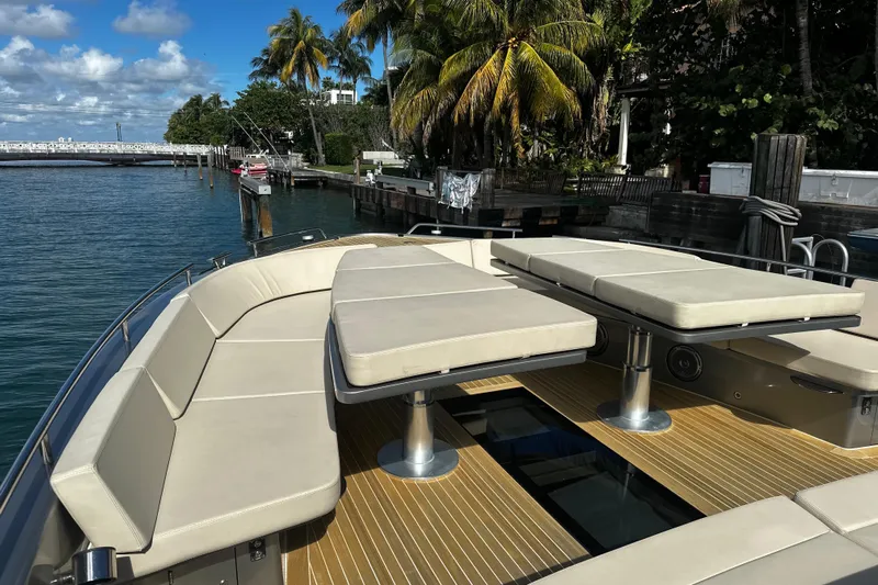 Yanina Yacht Photos Pics Luxurious CNM 54 yacht deck with seating, docked near palm trees, 2019 model.