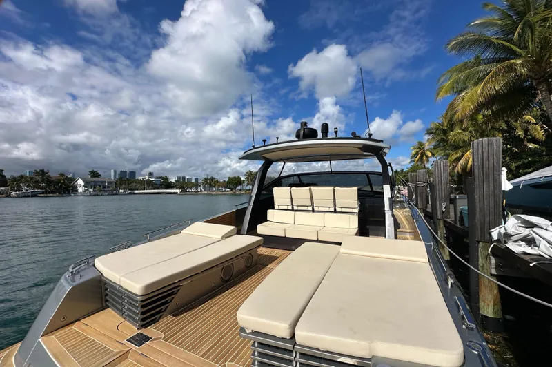 Yanina Yacht Photos Pics Luxurious 2019 CNM 54 yacht docked, featuring spacious sunbeds and elegant design under a clear blue sky.