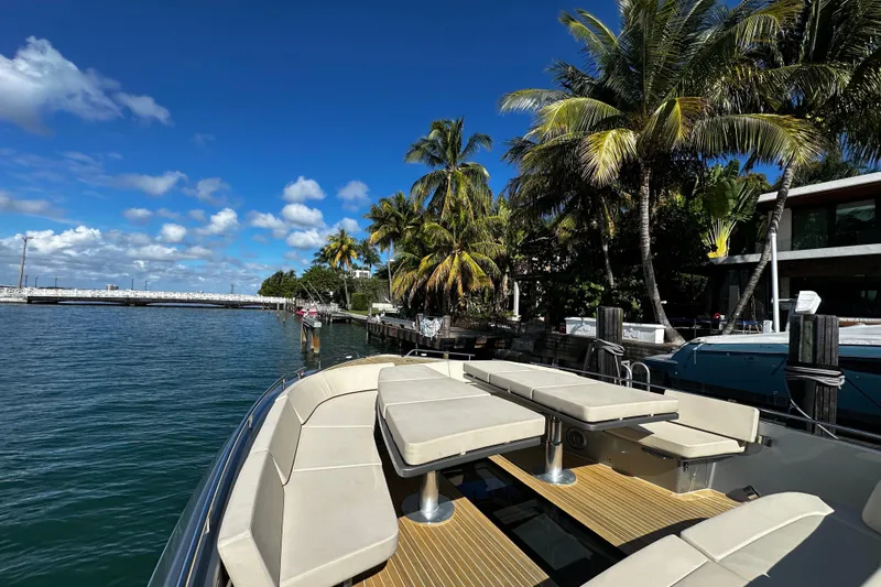Yanina Yacht Photos Pics Luxurious CNM 54 yacht docked by palm trees, clear blue sky, and calm waters.