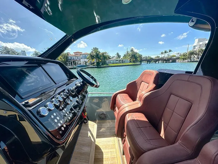B-offline Yacht Photos Pics Interior of 2019 SACS Rebel 40 boat with luxurious seating and control panel, overlooking waterway.