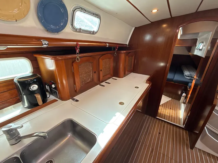 Gonzo Yacht Photos Pics Interior of 1997 Beneteau 50 yacht with wooden cabinetry and modern kitchen amenities.
