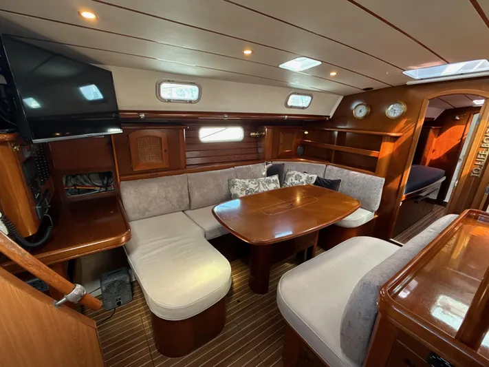 Gonzo Yacht Photos Pics Luxurious interior of a 1997 Beneteau 50 yacht with cozy seating and elegant wood finish.