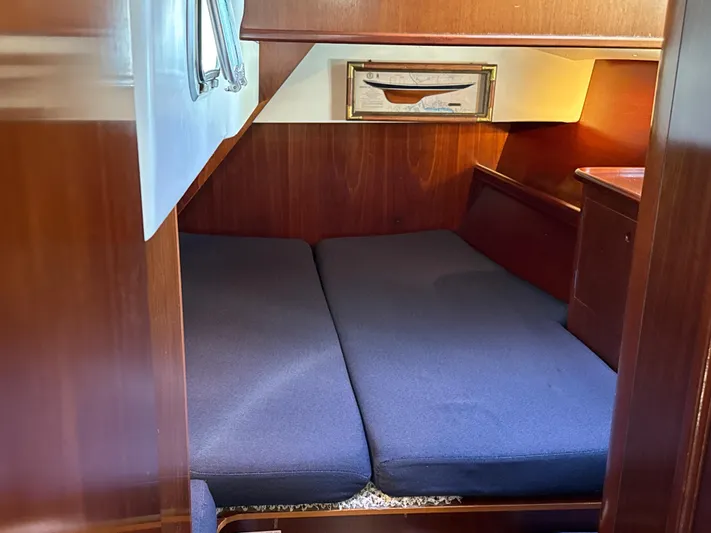 Gonzo Yacht Photos Pics Cozy cabin interior of a 1997 Beneteau 50 sailboat with blue cushions and wooden finish.