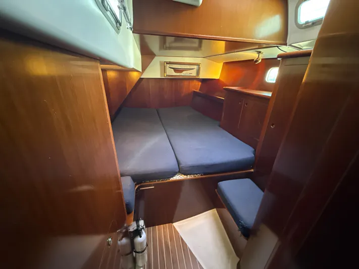 Gonzo Yacht Photos Pics Cozy cabin interior of a 1997 Beneteau 50 sailboat with wooden finishes and blue cushions.