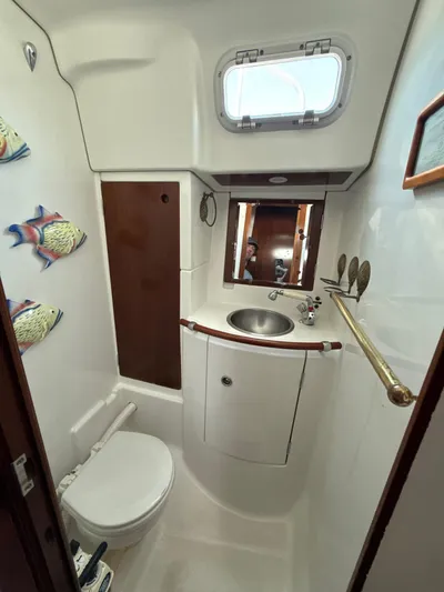 Gonzo Yacht Photos Pics Bathroom interior of a 1997 Beneteau 50 yacht, featuring sink, toilet, and nautical decor.
