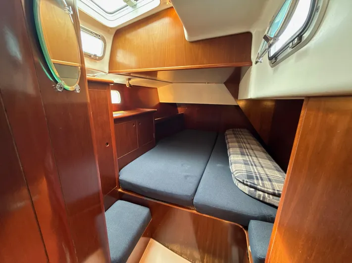 Gonzo Yacht Photos Pics Cozy cabin interior of a 1997 Beneteau 50 sailboat with wooden finishes and bedding.
