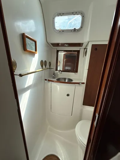 Gonzo Yacht Photos Pics Compact bathroom in a 1997 Beneteau 50 yacht, featuring a sink and porthole window.