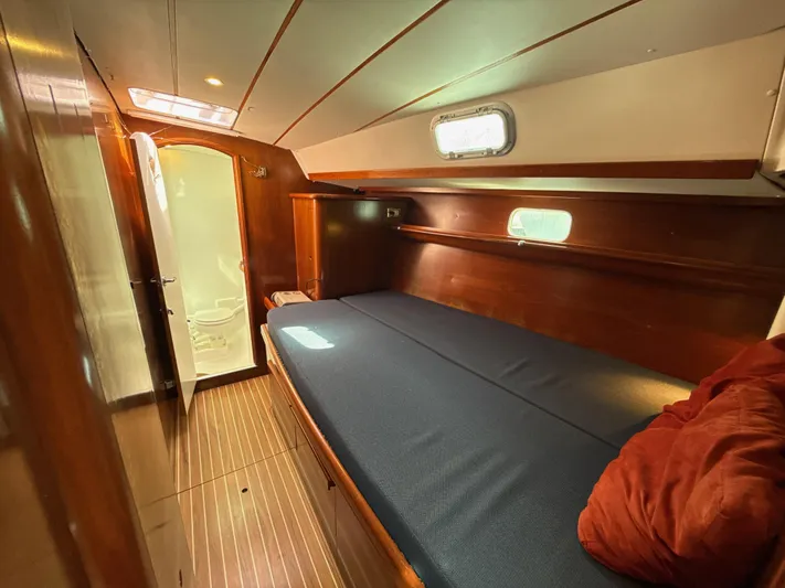 Gonzo Yacht Photos Pics Cozy cabin interior of a 1997 Beneteau 50 sailboat with wooden finishes and a comfortable bed.