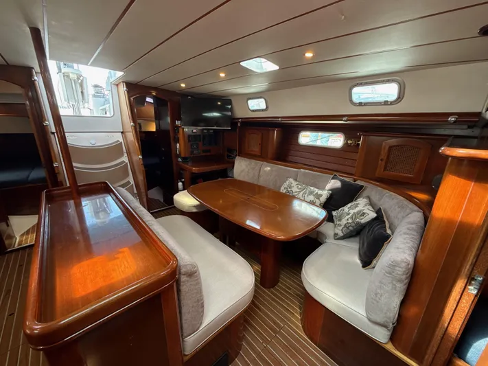Gonzo Yacht Photos Pics Luxurious interior of a 1997 Beneteau 50 yacht with elegant wood finishes and cozy seating.