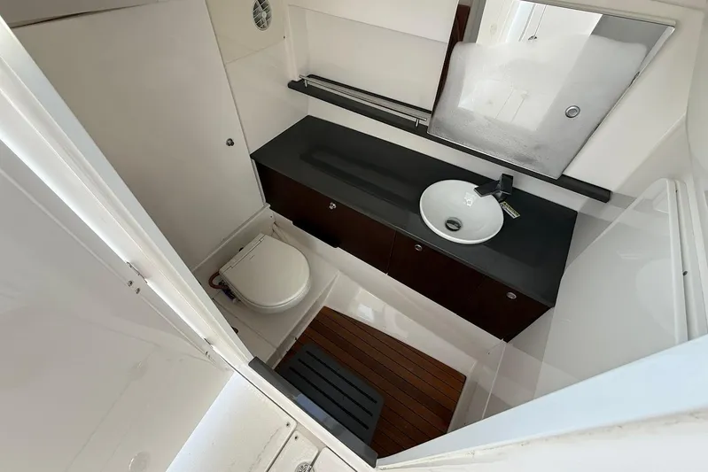 Untethered Yacht Photos Pics 2020 Everglades 340 Dual Console boat bathroom with sink, toilet, and wooden flooring.