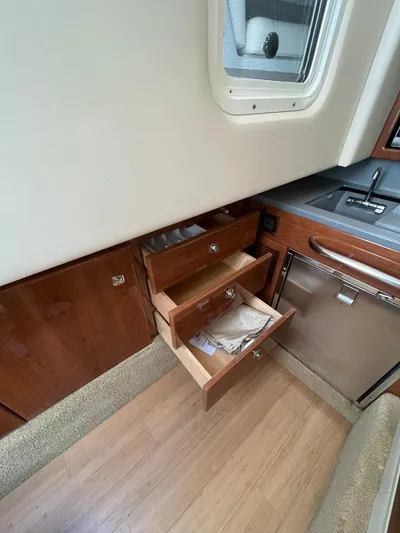  Yacht Photos Pics 2014 Formula 350 Crossover Bowrider interior with open wooden drawers and kitchenette.