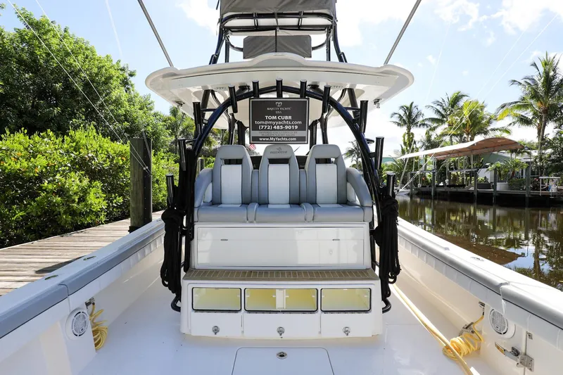 Grey Hull Yacht Photos Pics 2020 Regulator 41 boat with seating and storage, docked near lush greenery and waterway.