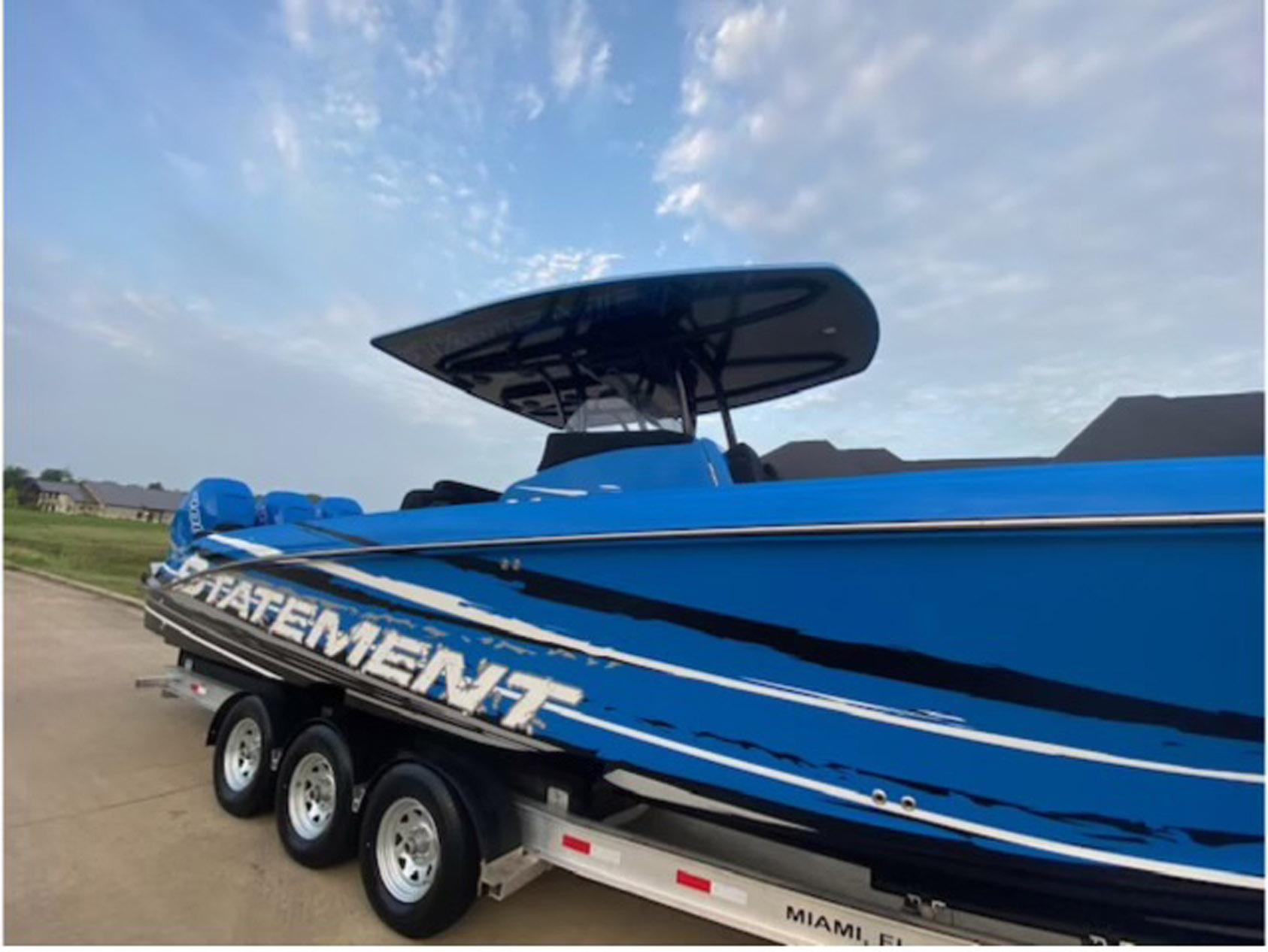 2021 Statement 380 Open boat in blue on a trailer, under a cloudy sky.