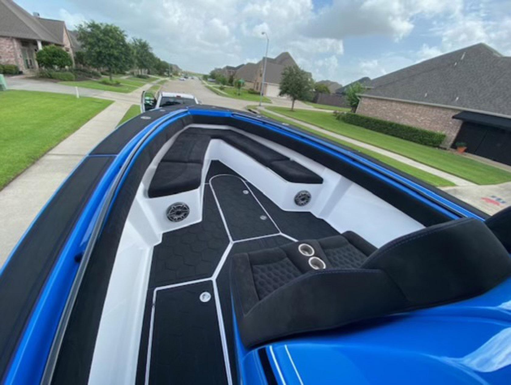 Blue 2021 Statement 380 Open boat with sleek interior design on a suburban street.