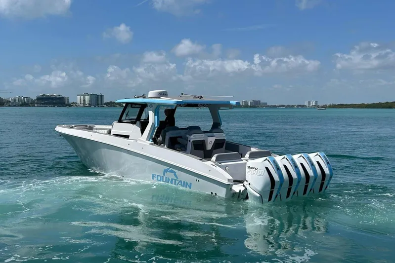  Yacht Photos Pics 2025 Fountain 38 SCX boat cruising on clear blue water under a sunny sky.