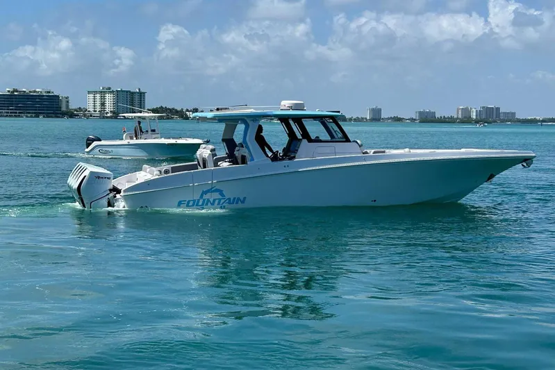  Yacht Photos Pics 2025 Fountain 38 SCX boat cruising on clear blue water under a partly cloudy sky.