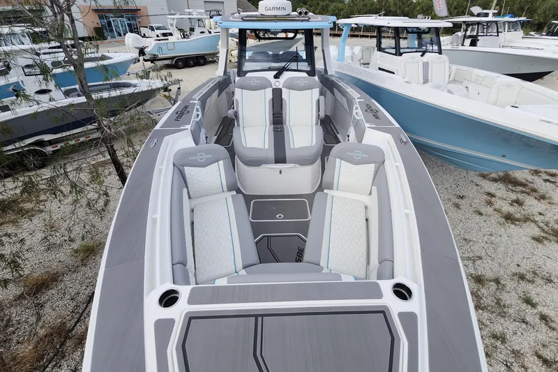  Yacht Photos Pics 2025 Fountain 38 SCX boat with sleek seating and modern design at a marina.