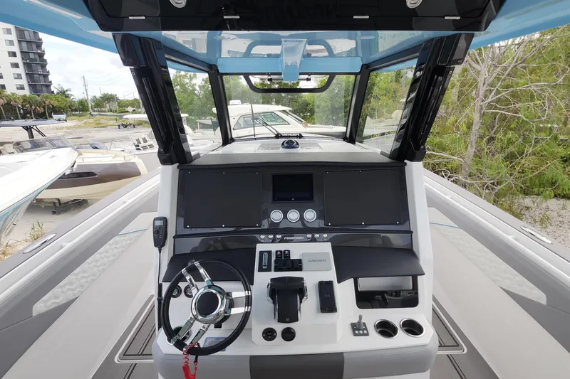  Yacht Photos Pics 2025 Fountain 38 SCX boat cockpit with modern navigation controls and steering wheel.