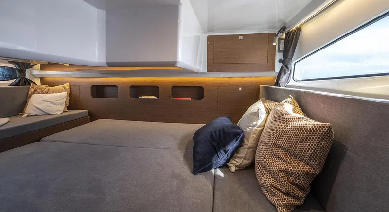  Yacht Photos Pics 2026 Beneteau Antares 11 Fly cabin interior with cozy seating and decorative pillows.