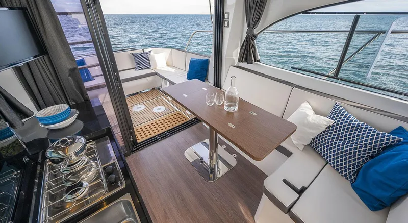  Yacht Photos Pics 2026 Beneteau Antares 11 Fly interior with ocean view, featuring elegant seating and dining area.