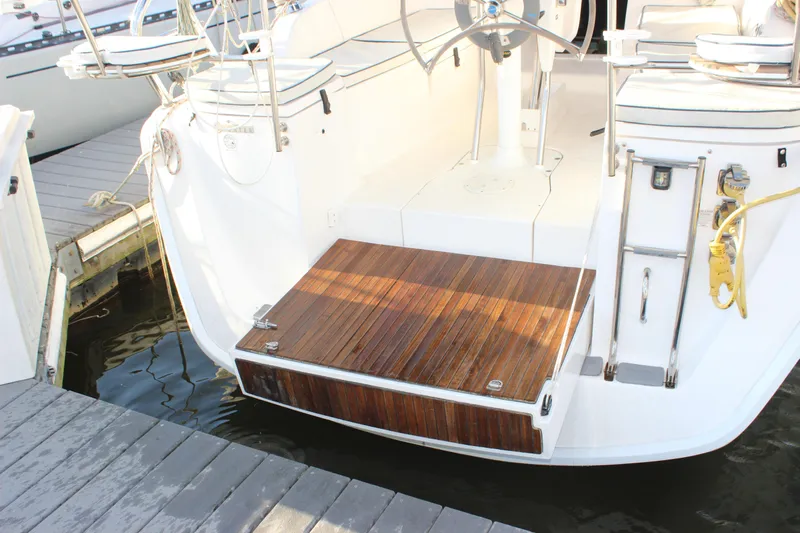  Yacht Photos Pics Hunter 33 sailboat (2014) with teak swim platform and dual steering wheels at dock.