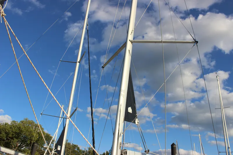  Yacht Photos Pics Masts of a 2014 Hunter 33 sailboat against a blue sky with clouds.