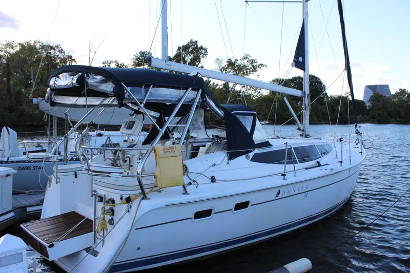  Yacht Photos Pics 2014 Hunter 33 sailboat docked on a calm river, featuring sleek design and modern amenities.