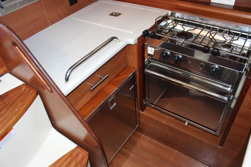  Yacht Photos Pics Compact kitchen area in a 2014 Hunter 33 sailboat with stove and storage.