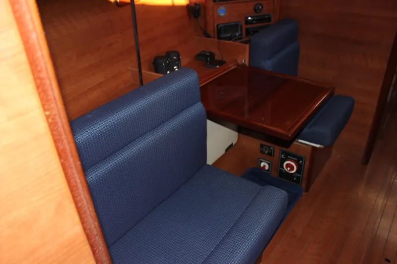  Yacht Photos Pics Interior of 2014 Hunter 33 sailboat with blue seating and wooden table.