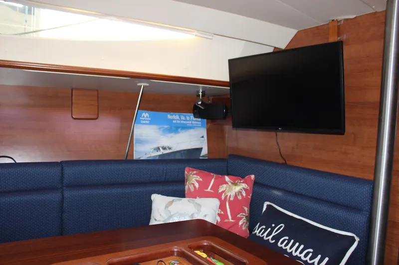  Yacht Photos Pics Interior of 2014 Hunter 33 yacht with TV, cushions, and wooden paneling.
